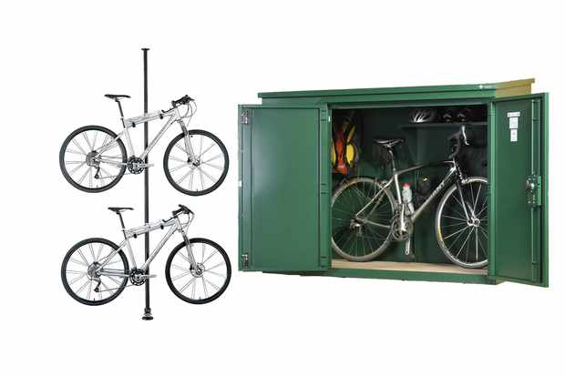 Photo of a bike stand with two bikes in it and a green metal bike shed on a white background